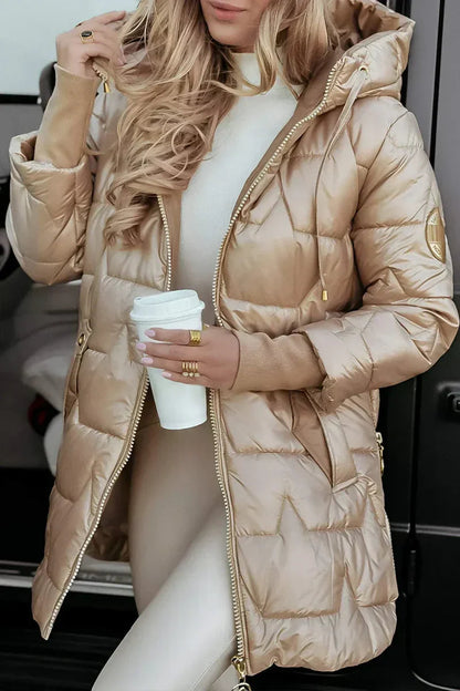 Person wearing a beige puffer coat holding a white cup.